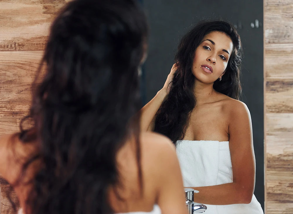 woman playing with long hair in towel | Ottawa Plastic Surgery in Ottawa, Canada