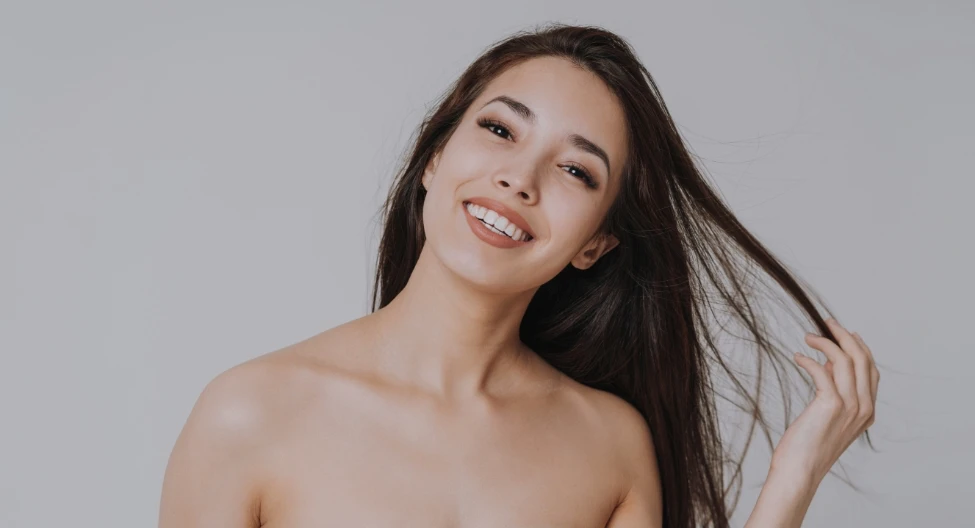 woman smiling pulling hair | Ottawa Plastic Surgery in Ottawa, Canada