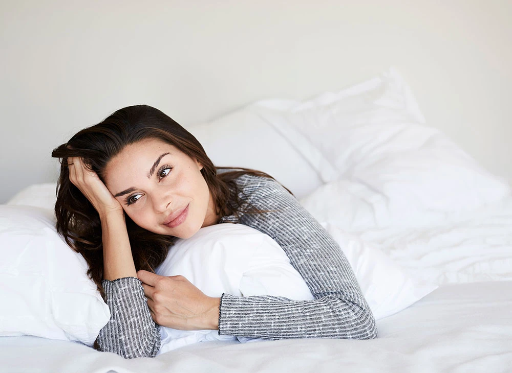 woman leaning against pillows | Ottawa Plastic Surgery in Ottawa, Canada